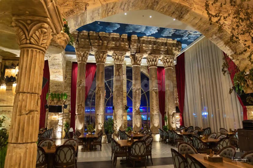 Al Meshwar Restaurant Dubai features a grand dining space with ancient-style stone columns and carved capitals under
