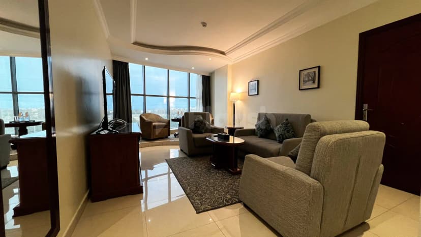 Meeting room at Crown Tower Al Jubail featuring floor-to-ceiling windows with city view and a glass partition