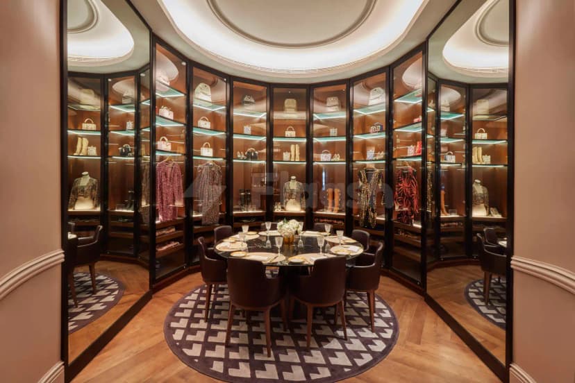 Circular dining table in La Brasserie Sur Le Boulevard, Dubai, surrounded by glass display cabinets with illuminated fashion