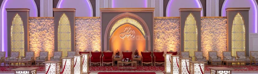 Ballroom at Al Jewan Hall Doha featuring an arched alcove with illuminated Arabic calligraphy and floral wall panels