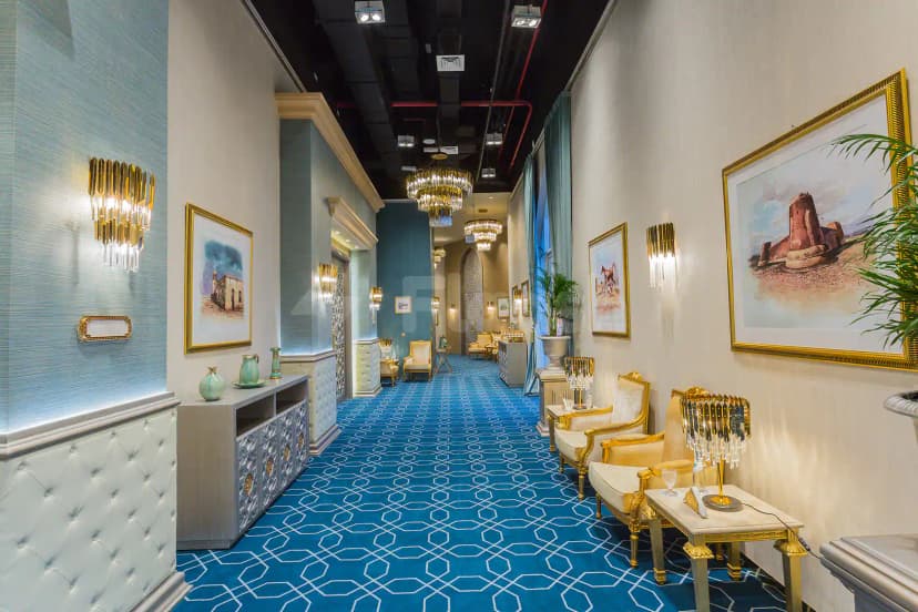 Entrance hall at White Palace Wedding Hall in Doha featuring a blue patterned carpet and gold-framed artwork