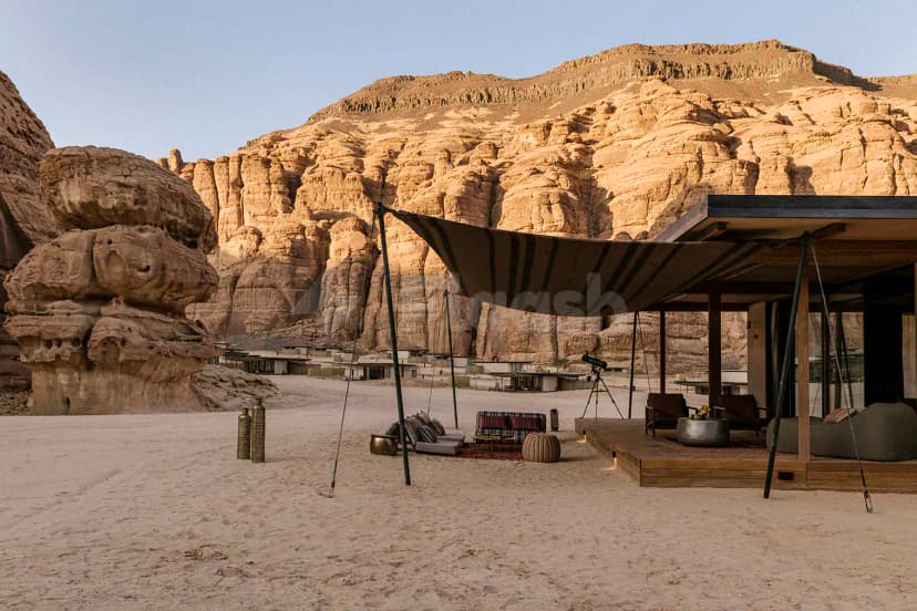 Terrace at Tama At Habitas AlUla in Al Ula featuring a wooden deck, striped canopy, and sand floor