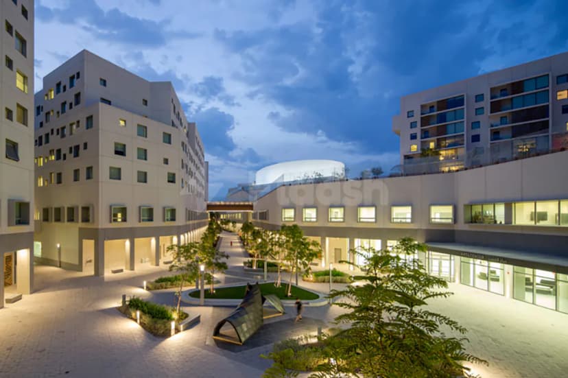 Paved courtyard at The Blue Hall Abu Dhabi with circular grass patch and metal sculpture
