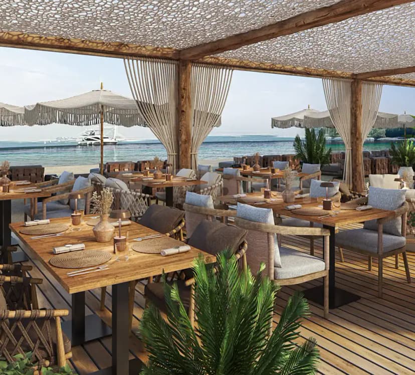 Open-air terrace at Peaches & Cream Beach Restaurant Dubai with macrame canopy, wooden tables, and sea view