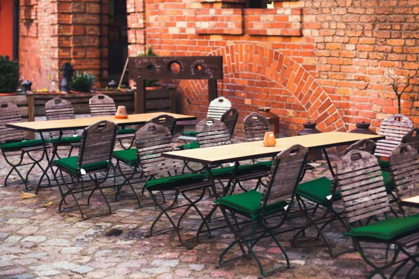 Terrace at Hoods Resto & Bar in Abu Dhabi featuring cobblestone flooring and a red brick wall