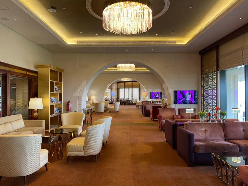 Momento Lounge Doha entrance hall featuring a crystal chandelier and arched doorways leading to further seating areas