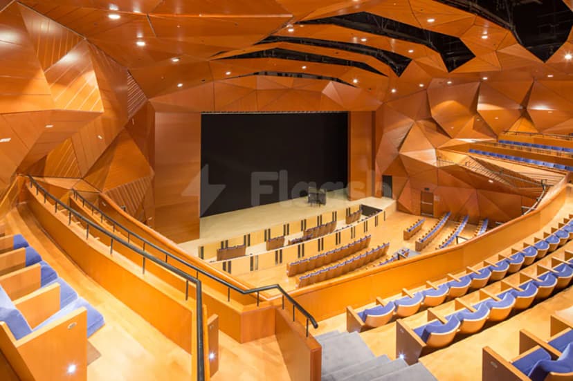 Ballroom at The Blue Hall Abu Dhabi featuring geometric wooden ceiling panels and tiered seating with blue upholstery