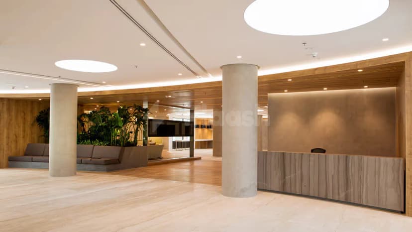 Entrance hall at Conference Hall Dubai Knowledge Park featuring a wooden reception desk, concrete pillars, and large circular