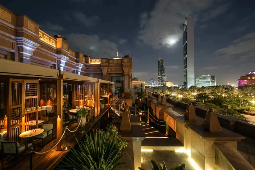 Rooftop terrace at Hakkasan Abu Dhabi featuring outdoor dining with wooden flooring and illuminated stone steps overlooking