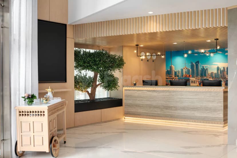 Reception desk at La Quinta by Wyndham Abu Dhabi Al Wahda featuring a marble counter, wooden slat ceiling