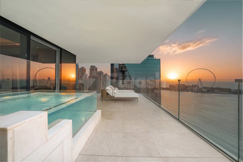Rooftop terrace at Five Luxe JBR Dubai featuring an infinity pool and glass railing with waterfront and city