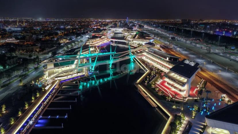 Rooftop terrace at Al Qana in Abu Dhabi featuring an illuminated turquoise bridge over a water canal
