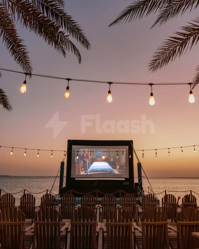 Outdoor cinema terrace at Bab Al Nojoum Hudayriyat Camp in Abu Dhabi with inflatable screen and string lights