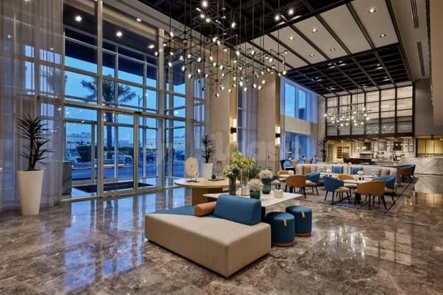 Entrance hall at Courtyard Jubail in Al Jubail featuring a marble floor and large glass windows