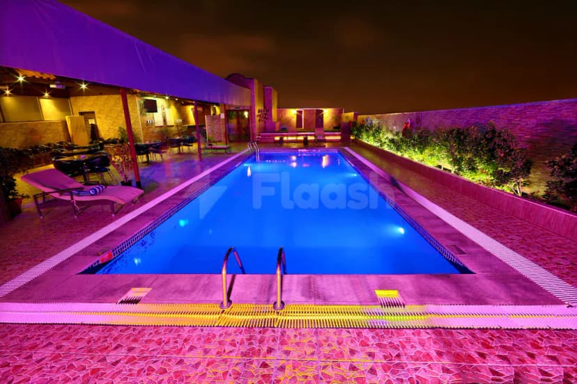 Rectangular swimming pool at Excelsior Hotel Downtown Dubai, featuring blue water, a metal ladder, and mosaic tile flooring