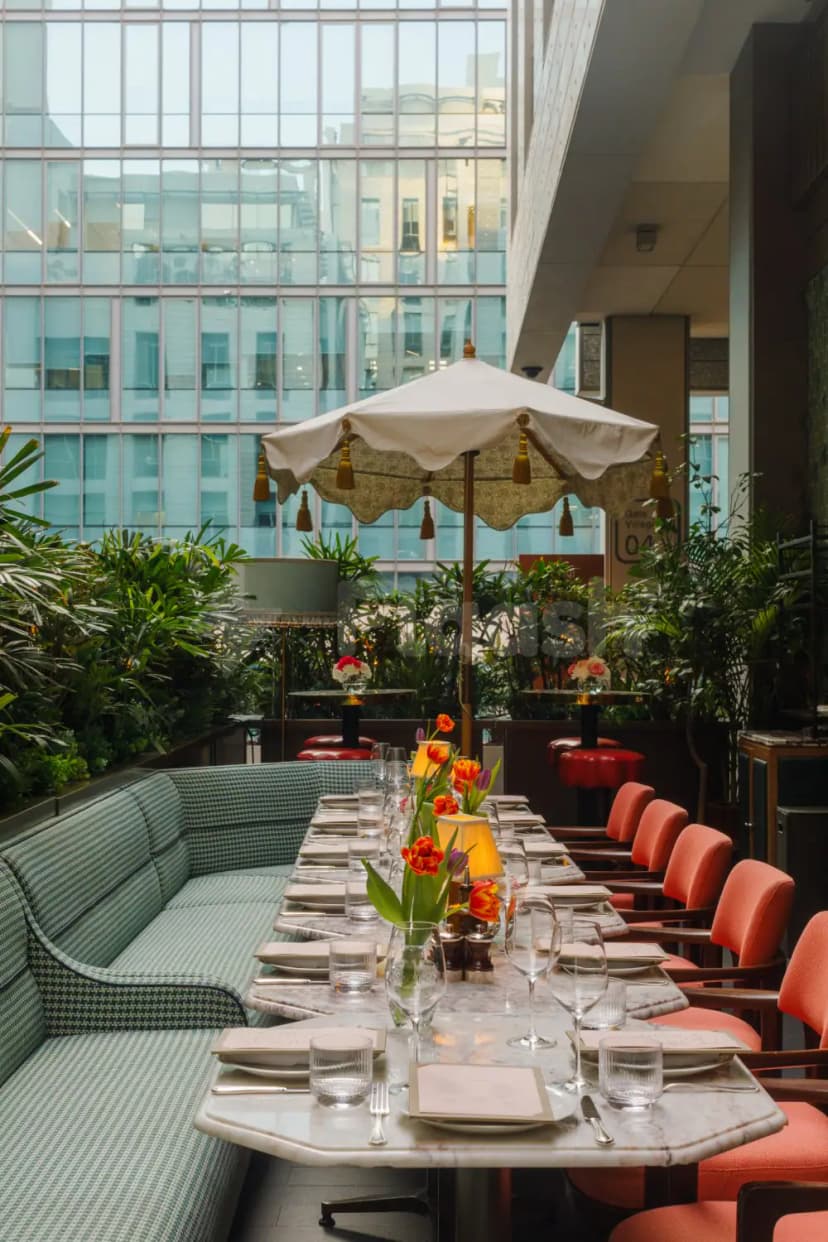 Long marble dining table at Alaya Dubai in Dubai, under a white parasol with tassels
