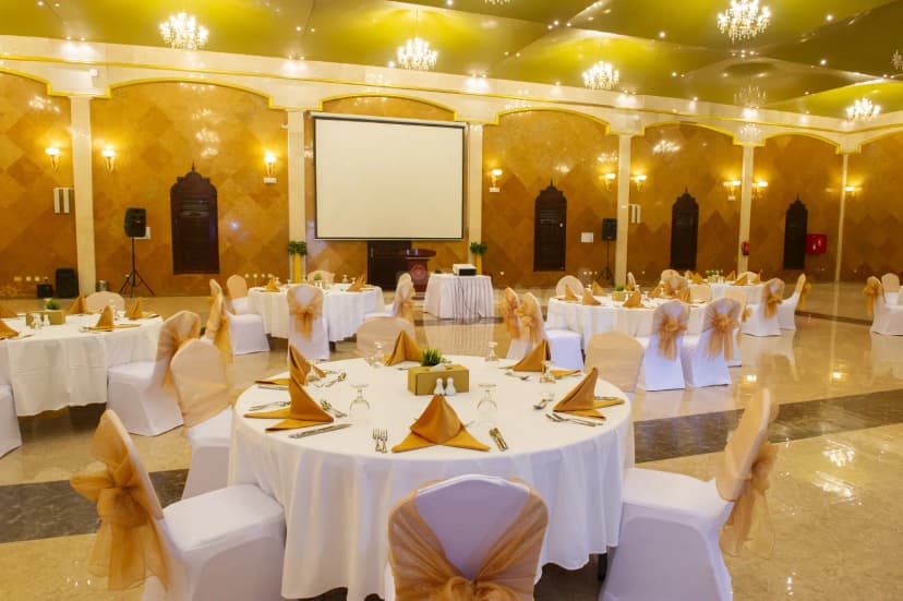 Ballroom at Tio Sea Resort Qatar in Doha set with round tables, white linens, gold napkins