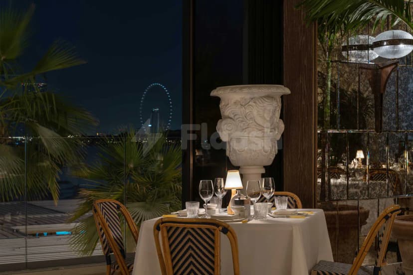 Dining area at Ristorante Loren in Dubai with ornate stone urn and waterfront night view
