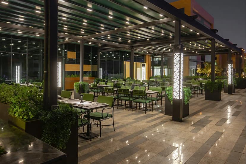 Rooftop terrace at Entrecôte Café de Paris Restaurant Riyadh, featuring a metal pergola, illuminated lattice columns