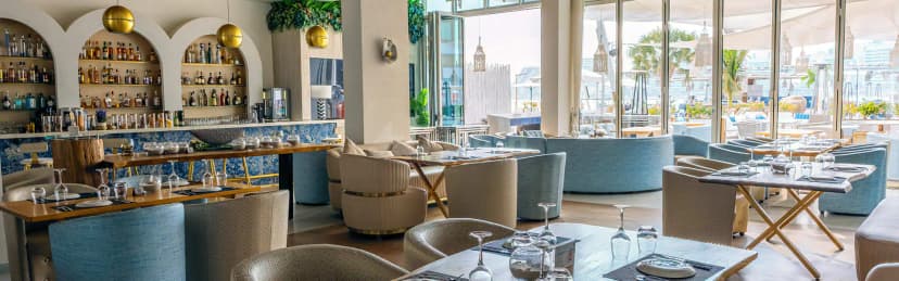 Restaurant at Cafe del Mar Beach Club Abu Dhabi with arched liquor shelves and large glass windows