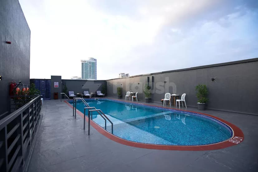 Rooftop swimming pool at Fortis Hotel Fujairah with blue mosaic tiles, red tile border, and grey stone flooring