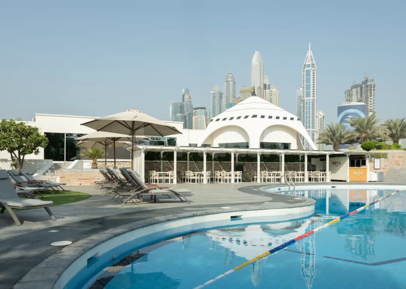Rooftop terrace at Emirates Golf Club in Dubai with swimming pool and city skyline backdrop