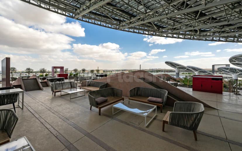 Rooftop terrace at The Nexus, Expo City Dubai, featuring a metal canopy structure and curved brown partitions