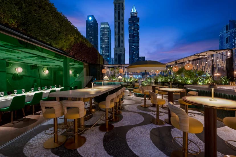 Rooftop terrace at Amazónico Dubai featuring a black and white mosaic floor and a green living wall
