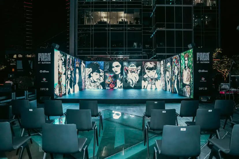 Rooftop terrace at Kanvas Dubai featuring an outdoor stage with a multi-panel digital art wall and arranged black