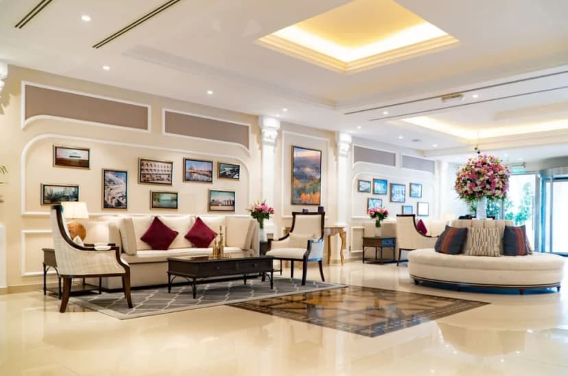 Entrance hall at Al Ain Palace Hotel in Abu Dhabi featuring a circular cream sofa and floral arrangement