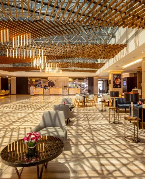 Entrance hall at Flora Inn Hotel Dubai Airport with wooden ceiling lattice casting geometric shadows