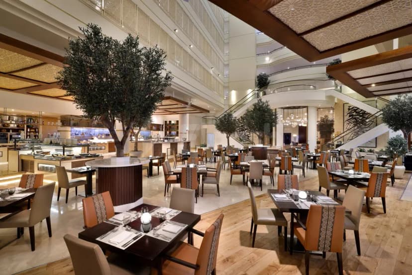 Brauhaus Restaurant Abu Dhabi features a spacious dining area with a central olive tree and an open kitchen