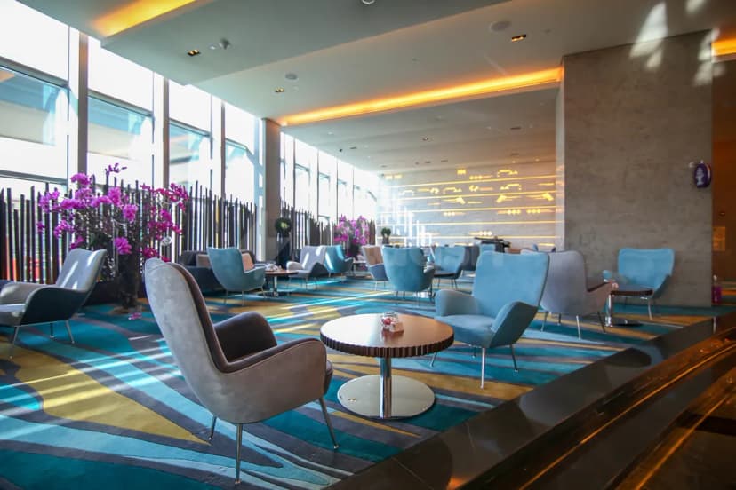Entrance hall at Mosaic Pool Lounge & Bar Downtown Dubai featuring modern lounge seating and purple orchid arrangements near