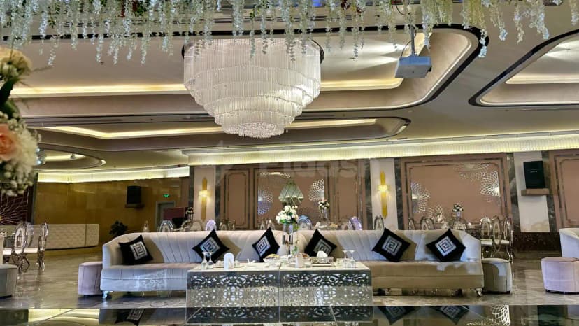 Ballroom at H Laylati Event Venue in Madinah featuring a large crystal chandelier and hanging white floral decorations