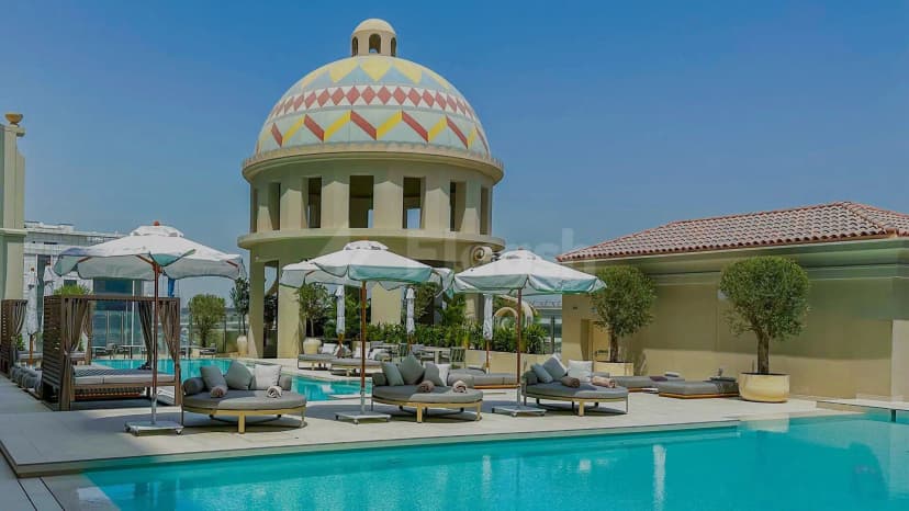 Rooftop terrace at Vera Versilia Dubai featuring a turquoise swimming pool and a circular dome structure with patterned
