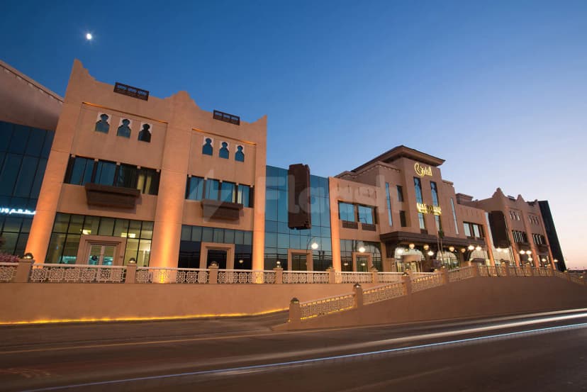 Hotel facade of Al Mashreq Boutique Hotel in Riyadh featuring arched windows, decorative wooden balconies, and illuminated signage