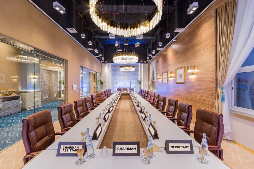 Boardroom at White Palace Wedding Hall in Doha featuring a long table with nameplates and chandeliers
