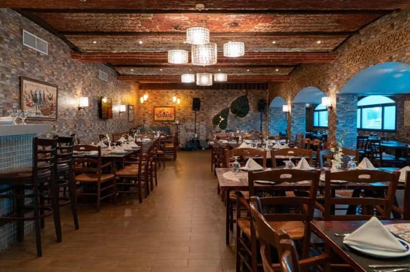 Restaurant interior at Al Ain Palace Hotel in Abu Dhabi featuring stone walls, an exposed brick ceiling
