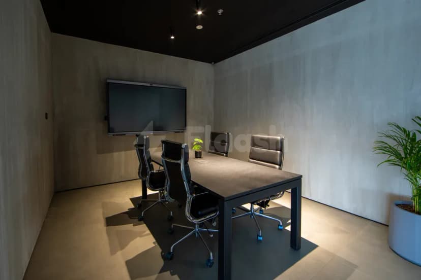 Boardroom at AXD Space Membership Club in Dubai featuring a rectangular table, black leather chairs with metal frames