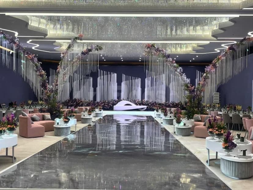 Ballroom at Pullman Doha West Bay, Doha, with crystal ceiling installation and floral arches over polished marbleomics walkway