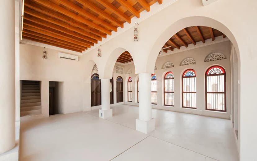 Entrance hall at The Flying Saucer Sharjah featuring white plaster walls, arched doorways with stained glass windows