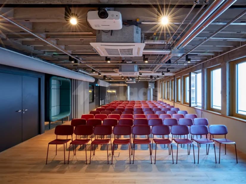 Rows of chairs in meeting room at Ernst Biergarten Restaurant Dubai with exposed industrial ceiling and hanging projector