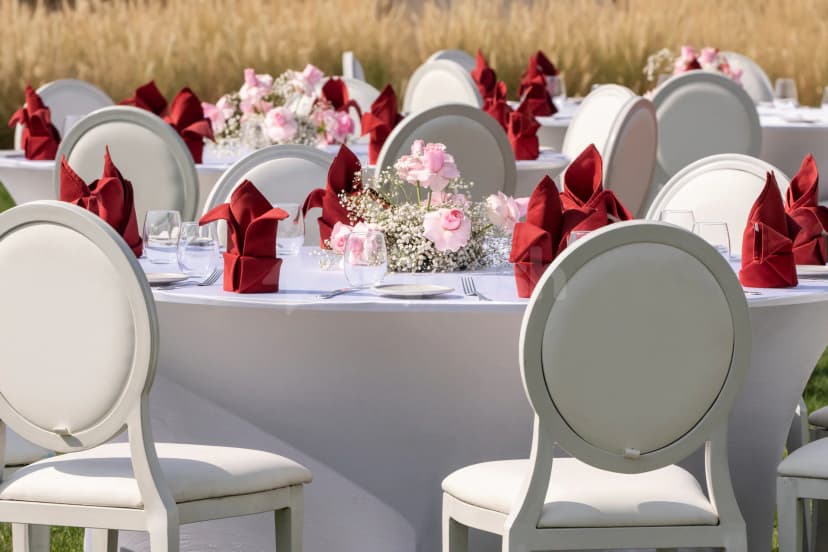 Rooftop terrace at Yas Acres Golf & Country Club in Abu Dhabi with white round tables and pink rose