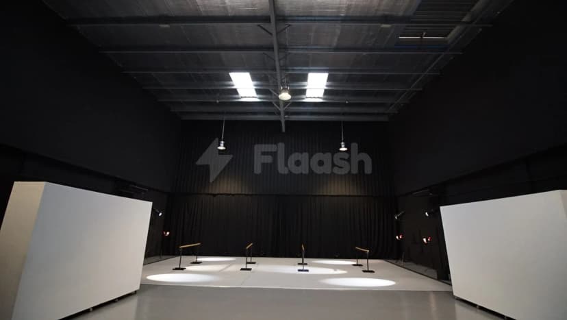 Sima Performing Arts Dubai meeting room with black curtain backdrop, white modular panels, and circular spotlight pools