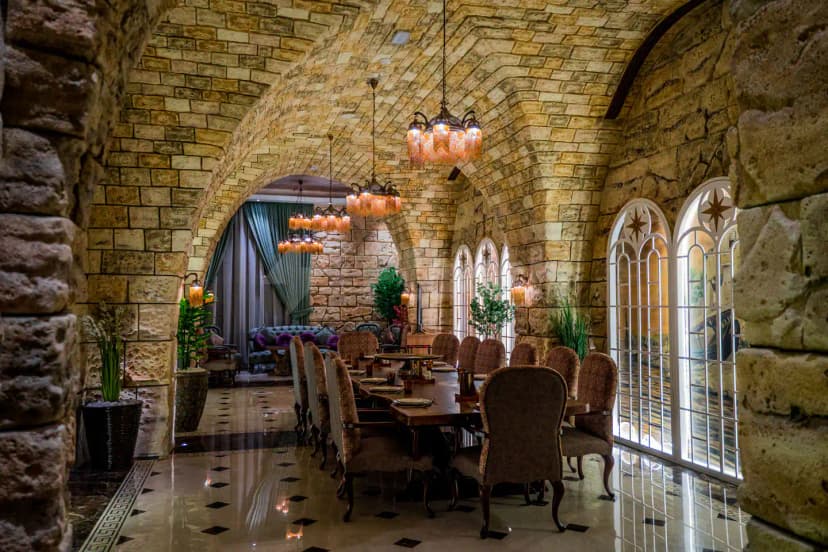 Al Meshwar Restaurant Dubai features a stone-arched dining hall with vaulted ceilings and ornate pendant lights