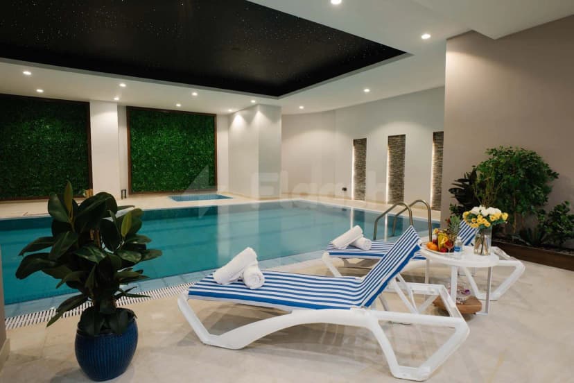 Indoor swimming pool at Cantonal Hotel by Warwick in Riyadh featuring a black starry ceiling and green living