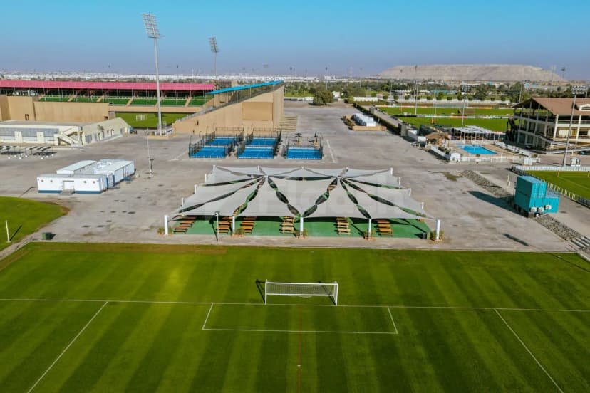 Green football pitch with white goalpost at The Sevens Stadium in Dubai, featuring a tensile fabric canopy