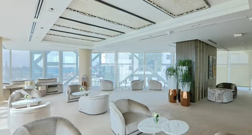 Entrance hall at Shaza Doha featuring large floor-to-ceiling windows with city views and a white ceiling