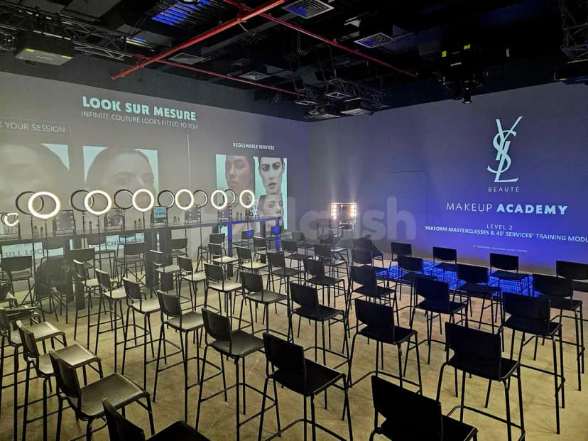 Meeting room at Kanvas Dubai with black chairs, ring lights, makeup stations, and YSL Beauté digital wall projections