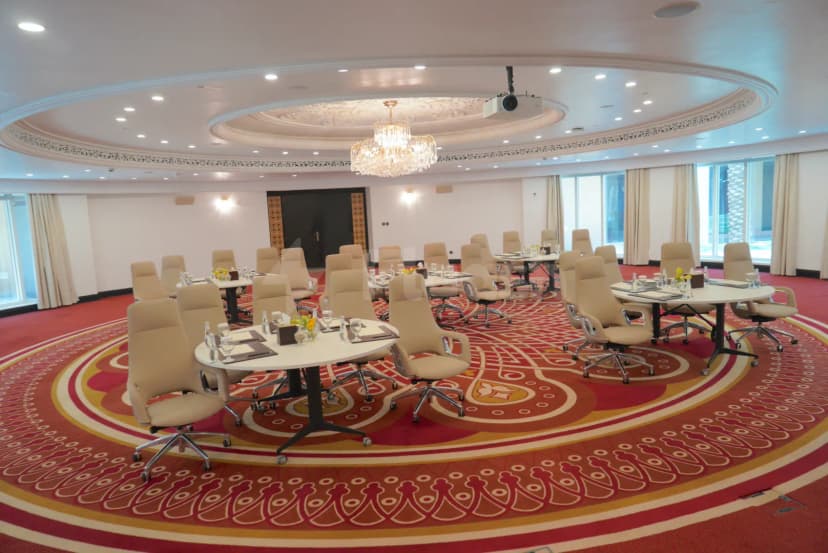 Meeting room at Al Mashreq Boutique Hotel in Riyadh featuring a circular red patterned carpet and a central